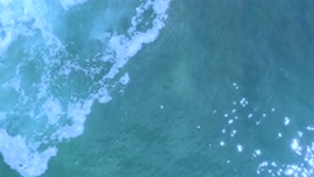 LOS CABOS MEXICO-2020: Foamy Water Encountering Clear Water With Sun Reflection