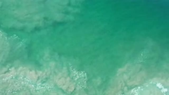 LOS CABOS MEXICO-2020: Blue Green Ocean Water Mixing Tan Silt And Sand Ebbing