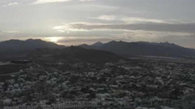 LOS CABOS MEXICO-2020: Flying Over A City During Sunset Headed For The Mountains