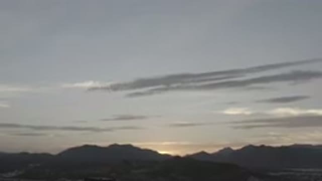 LOS CABOS MEXICO-2020: Sunset Peeking Up Through The Mountains Over A Sprawling City