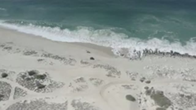 LOS CABOS MEXICO-2020: Slow Panning Shot Of Waves Slowly Crashing On A Beach