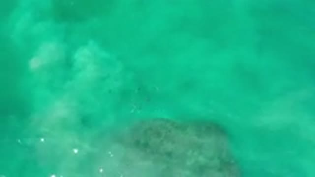 LOS CABOS MEXICO-2020: Cloudy Water Flowing Over A Large Rock In The Middle Of