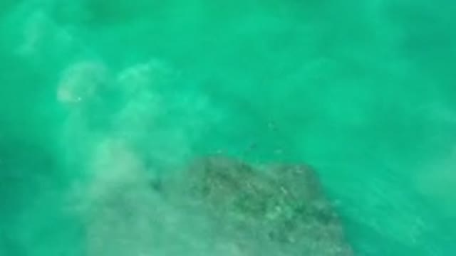 LOS CABOS MEXICO-2020: Green Ocean Water Rippling Over Large Rocks In The Sea