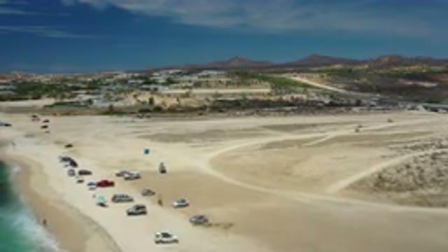 LOS CABOS MEXICO-2020: Camera Panning Over Sandy Beach With Parked And Driving Cars