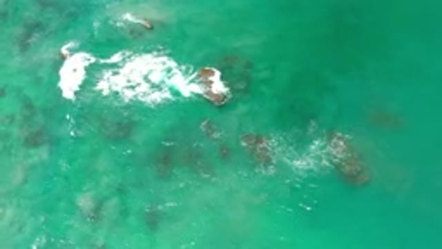 LOS CABOS MEXICO-2020: Waves Crash Over A Series Of Rocks In Blue Tropical Calm