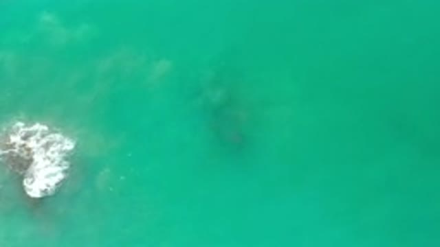 LOS CABOS MEXICO-2020: Waves Crashing Over A Rock On A Calm Green Ocean
