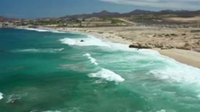 LOS CABOS MEXICO-2020: Flying Over The Ocean As Waves Crash Along An Empty Beach