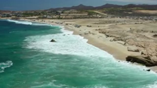LOS CABOS MEXICO-2020: The Clear Blue Ocean With White Waves Hitting A Barren Shore
