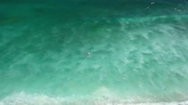 LOS CABOS MEXICO-2020: A Surfer On A Surfboard Paddles Out To Sea Threw Surf And