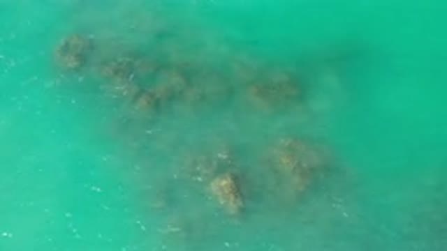LOS CABOS MEXICO-2020: Blue Ocean Waves Flowing Up And Over A Brown Rocky Coral