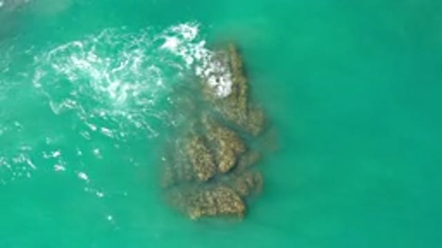 LOS CABOS MEXICO-2020: Sea Tides Crashing Onto A Rock On A Green Background
