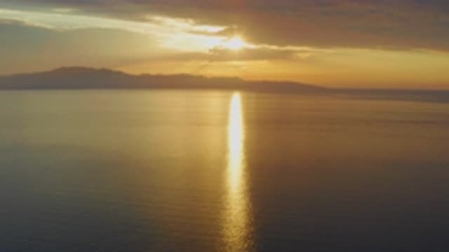 EL SARGENTO LA VENTANA MEXICO-2020: Slow Pan Above Calm Water At Sunset With Golden Light
