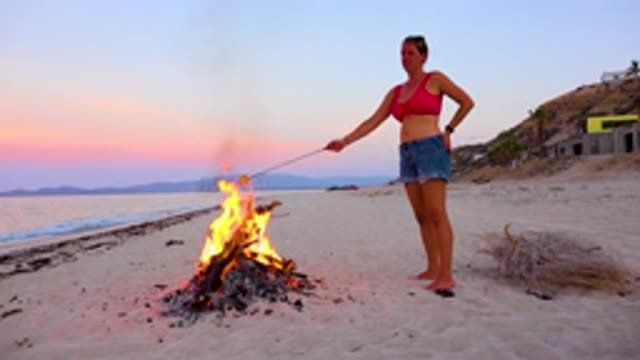 EL SARGENTO LA VENTANA MEXICO-2020: Young Women Roasts Marshmallow In Fire On Beach