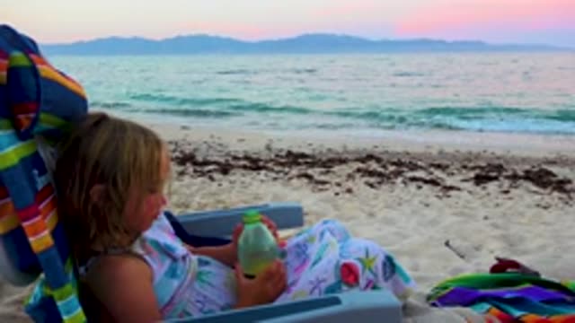 EL SARGENTO LA VENTANA MEXICO-2020: A Little Kid Drinks From A Battle While Sitting On The Beach