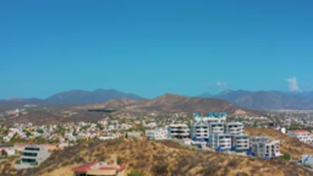LOS CABOS MEXICO-2020: Clear Blue Sky Sits Above A Bustling City Mountains And