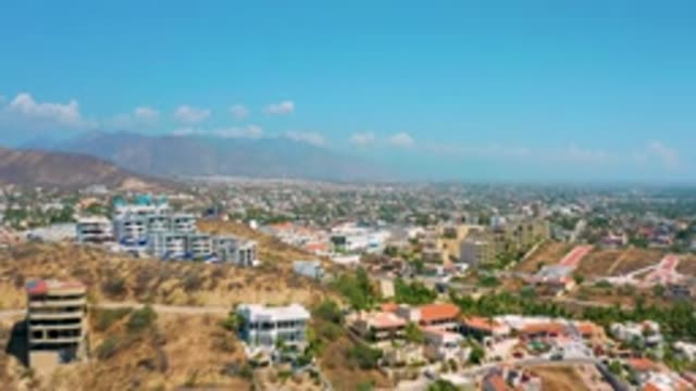 LOS CABOS MEXICO-2020: Camera Glides Forward Underneath Blue Skies And Multiple Buildings