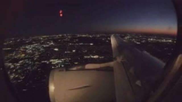 LOS CABOS MEXICO-2019: Airplane View Out of Window Over Lit City at Night