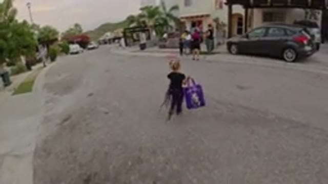 LOS CABOS MEXICO-2019: Child With Purple Bag Crosses Street To Join Group Of People