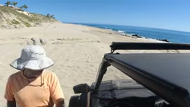 LOS CABOS MEXICO-2019: A Person Near His Car On The Beach With The Clear Blue
