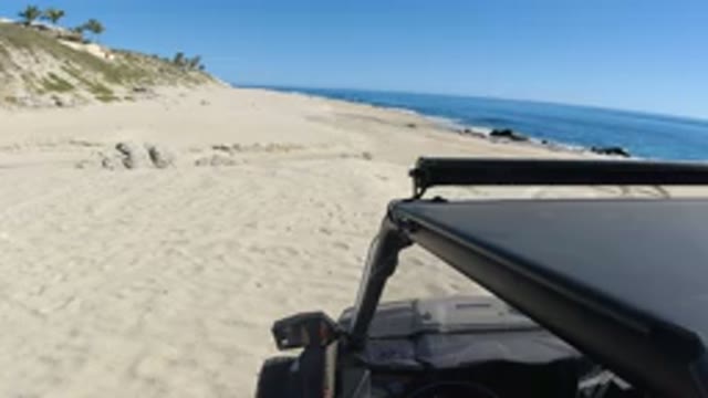 LOS CABOS MEXICO-2019: Driving A Black Car Along The Sea When The Weather's