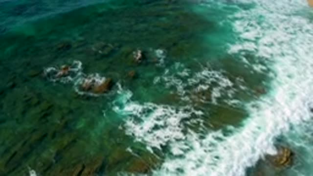 SHIPWRECKS BEACH BCS MEXICO-2020: Choppy Blue Ocean Waves Pass Over Rough Rocky