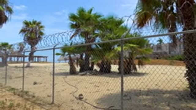 SAN JOSE DEL CABO MEXICO-2020: Sandy Area With A Barbed Wire Fence And Buildings