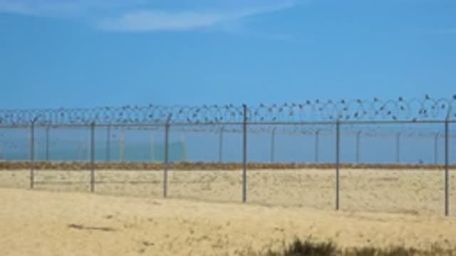 SAN JOSE DEL CABO MEXICO-2020: Heavily Barbed Wire Fence On A Beach Zooms Out