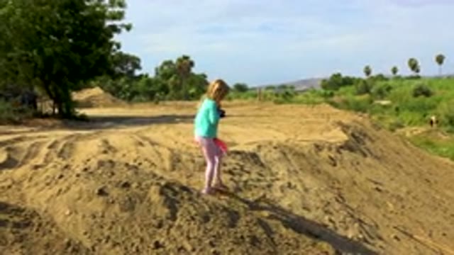 Young Girl Walking Down Sandy Hill