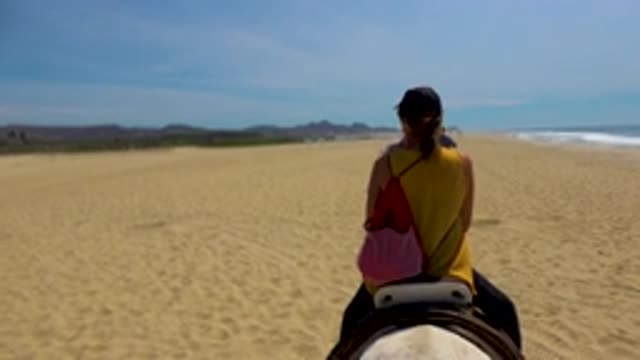 SAN JOSE DEL CABO MEXICO-2020: Man And Woman Riding Horseback On A Sandy Beach