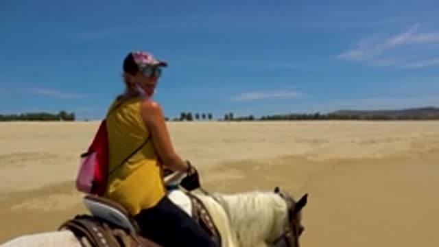 SAN JOSE DEL CABO MEXICO-2020: Smiling Woman in Yellow Top Riding Horse on Beach