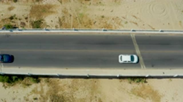 SAN JOSE DEL CABO MEXICO-2020: Black Car Driving Behind White Car On A Bridge