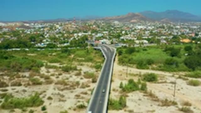 SAN JOSE DEL CABO MEXICO-2020: Long Black Concrete Road with White Car Running