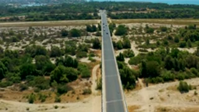 SAN JOSE DEL CABO MEXICO-2020: Six Cars Crossing a Bridge Over Trees on a Sunny Day