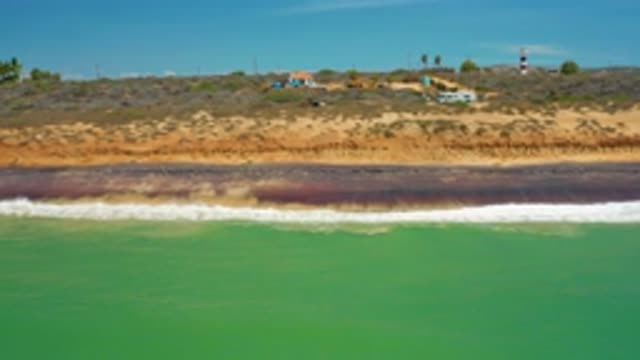 SAN JOSE DEL CABO MEXICO-2020: Green Sea Water and White Waves Hitting the Beach
