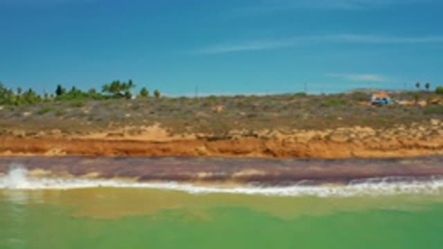 SAN JOSE DEL CABO MEXICO-2020: Crashing Green Waves Against Brownish Orange Land