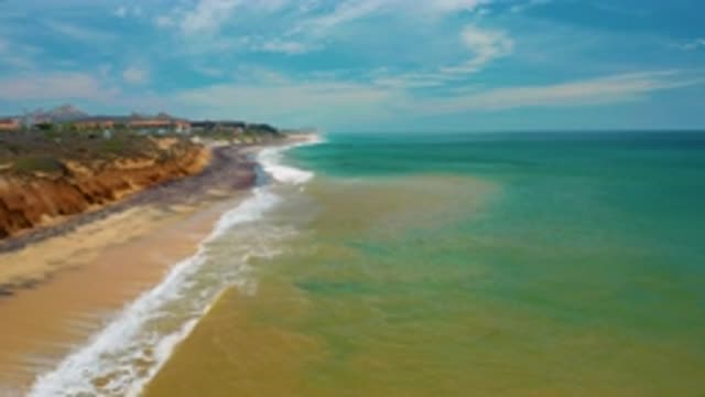 SAN JOSE DEL CABO MEXICO-2020: Aerial View of Green Sea Waves Breaking on Sandy Beach
