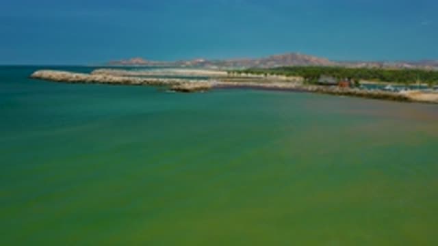 SAN JOSE DEL CABO MEXICO-2020: Green Seawater Flows Toward A Rocky Seawall With