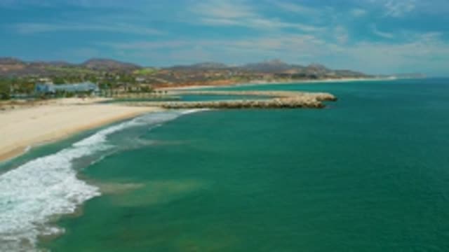 SAN JOSE DEL CABO MEXICO-2020: Open Blue Sea Washes Against Sandy Shore And Rock