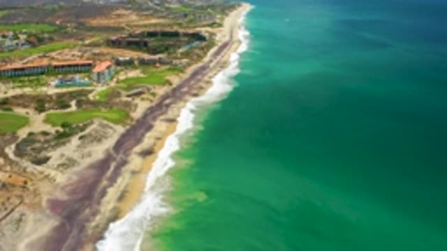 SAN JOSE DEL CABO MEXICO-2020: Still Water Washes Against Shore Lined With Mountains