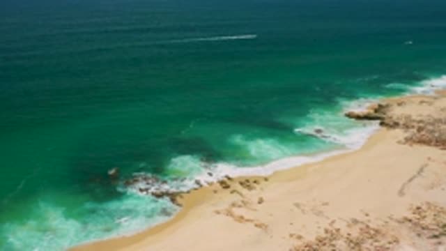 SAN JOSE DEL CABO MEXICO-2020: Bright Green-Blue Water Rushing Into Shoreline Of