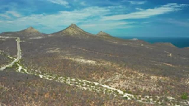 SAN JOSE DEL CABO MEXICO-2020: A Road Obtrusively Divides A Vast Mountain Range