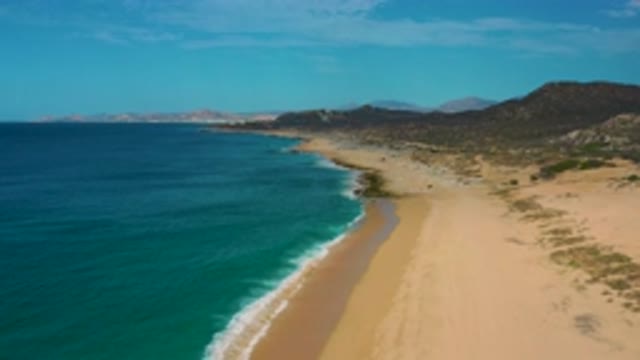 LAGUNA BEACH BCS MEXICO-2020: Ocean Waves Crashing Against The Sand Under A Clear Sky