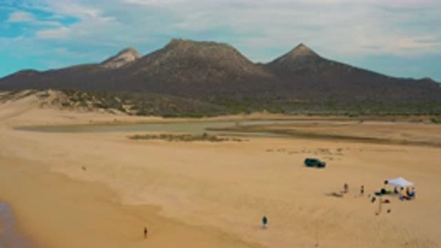 LAGUNA BEACH BCS MEXICO-2020: Car Driving Across Desert Beach Showing Massive Mountains