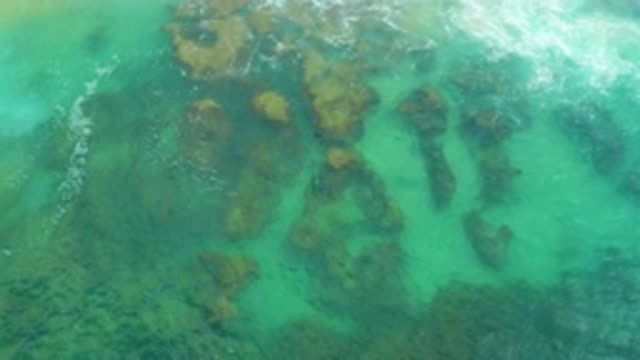 LAGUNA BEACH BCS MEXICO-2020: Green Water Washing Over Brown Rocks In The Ocean
