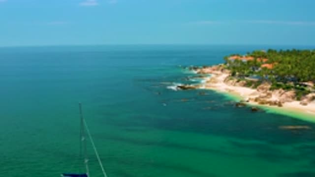 PALMILLA BEACH BCS MEXICO-2020: Boat Sits Atop Calm Blue Sea Water With Rocky Shoreline