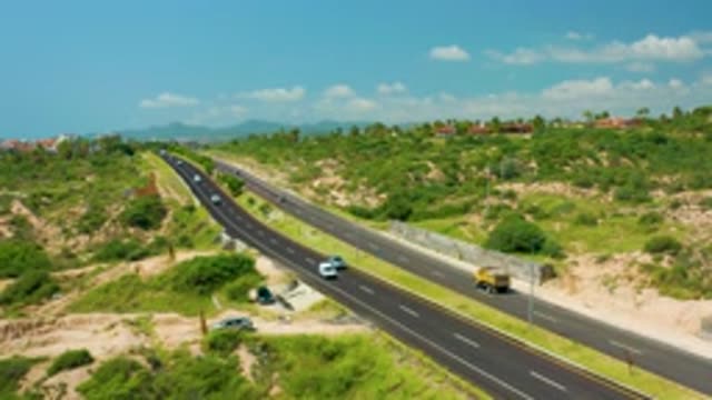 DREAMS BEACH BCS MEXICO-2020: Long Black Concrete Road With Many Cars And Yellow Lorry