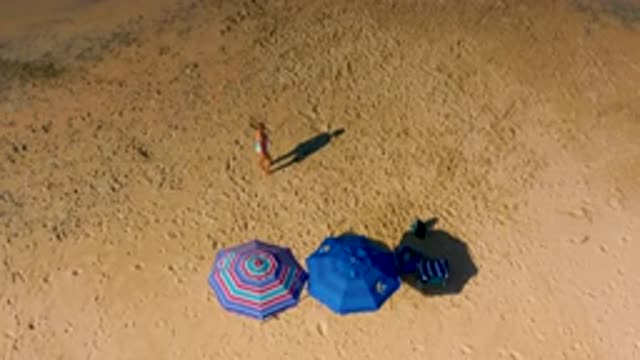 CERRITOS BCS MEXICO-2020: A Woman And Her Dog Walking Around A Beach Dotted With Umbrellas