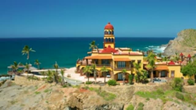 CERRITOS BCS MEXICO-2020: Big Tall Building at Crystal Clear Sea Shore with Green Coconut Trees