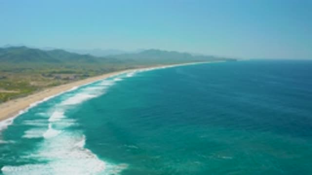 CERRITOS BCS MEXICO-2020: Clear Blue Water Breaks On Shore With Lush Mountains
