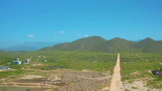 CERRITOS BCS MEXICO-2020: Long Road with Green Plants Around a Building Near a Sky